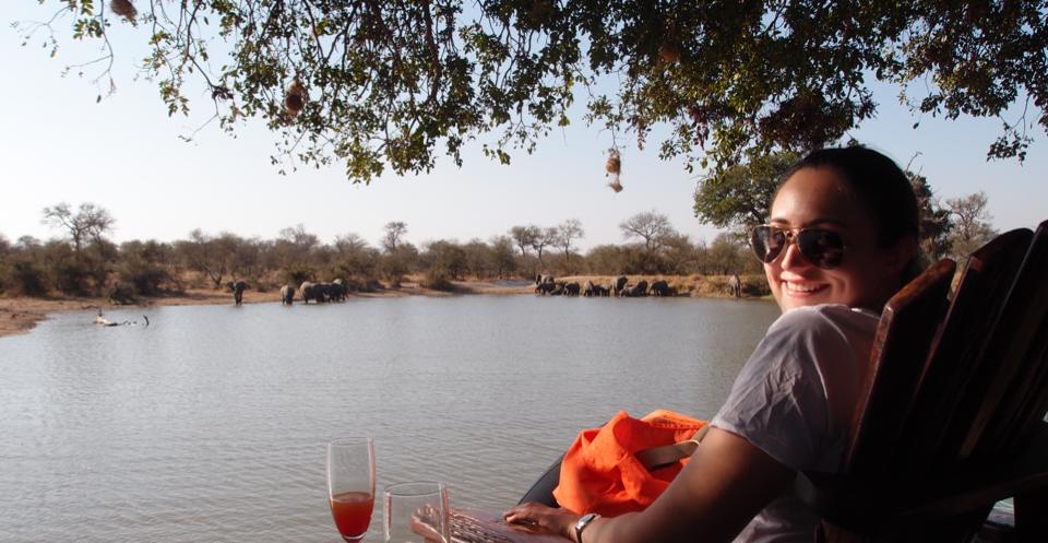 Enjoying time off in South Africa, thanks to my pre-vacation checklist! Overlooking a waterhole with elephant playing, while drinking a mimosa.